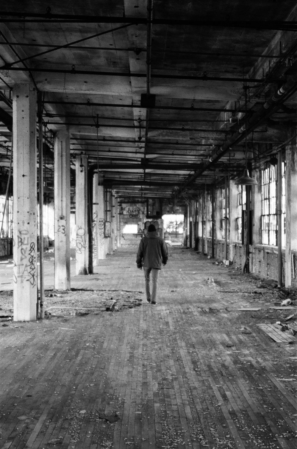 A person walking away in a large run-down building