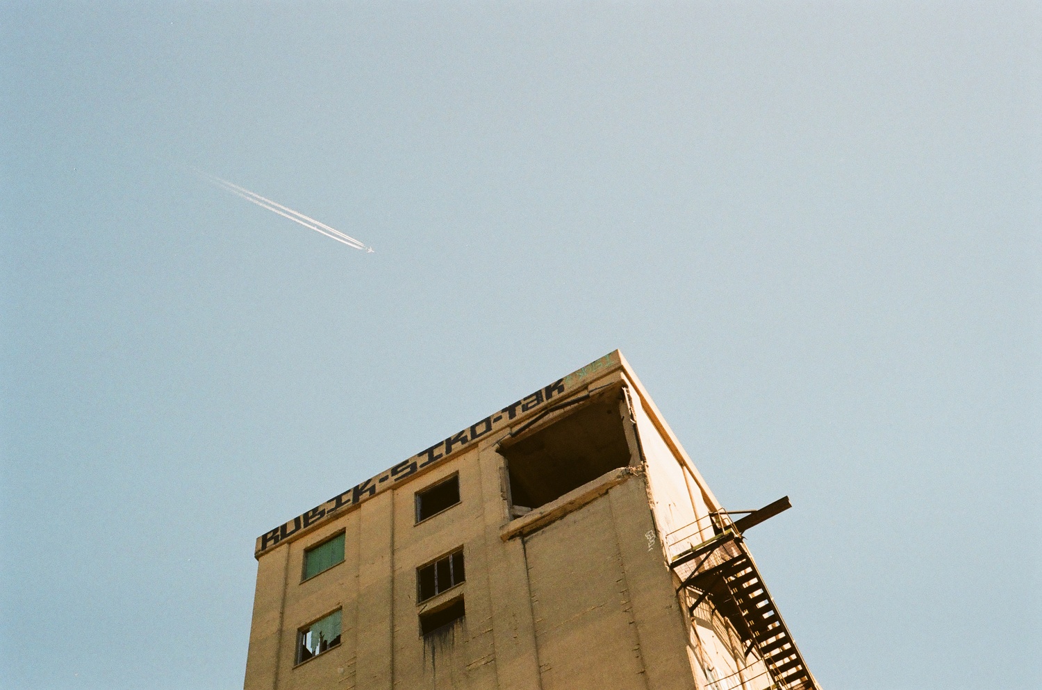 A plane flying over an abandoned building