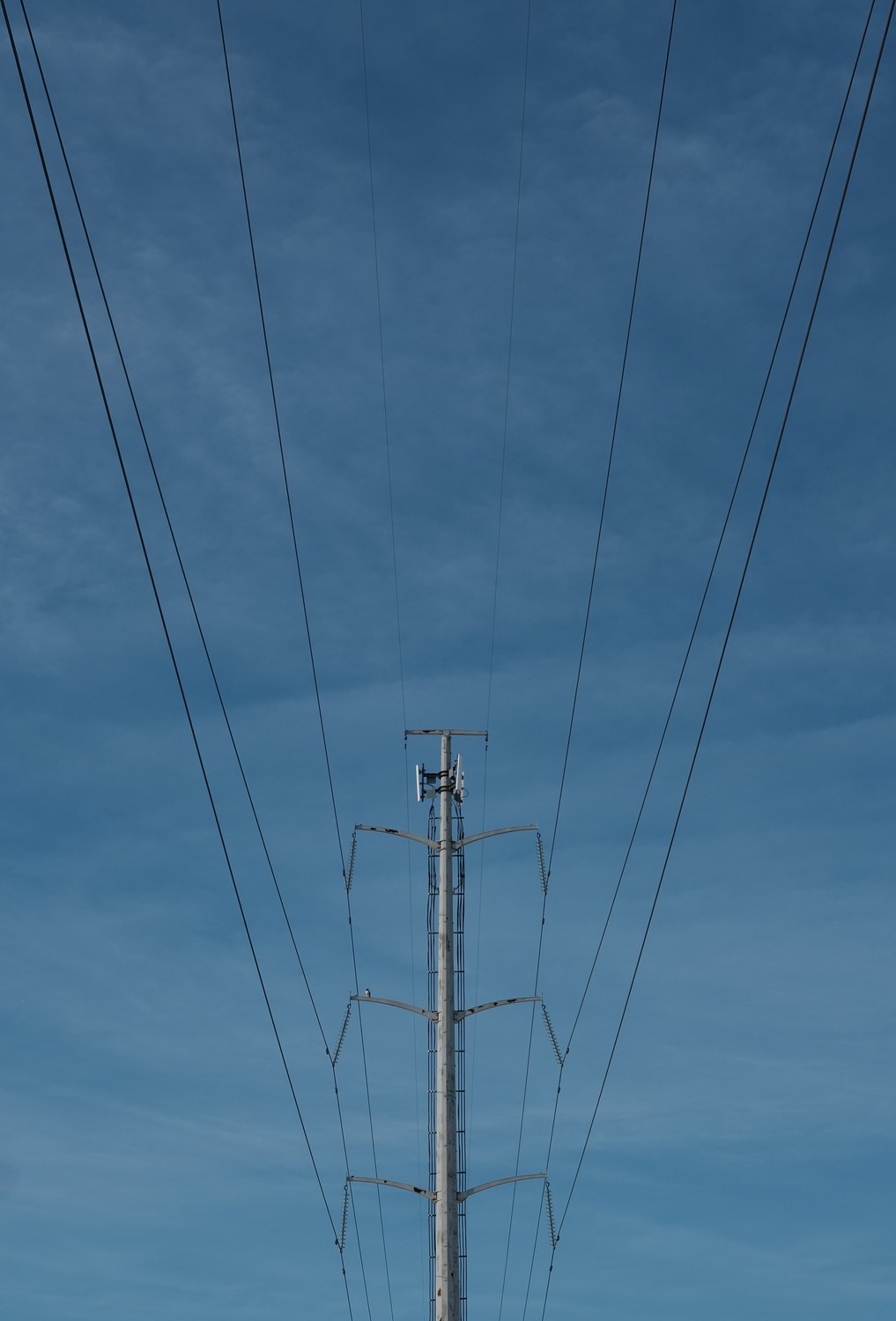 A symmetrical image of power lines and the tower supporting them